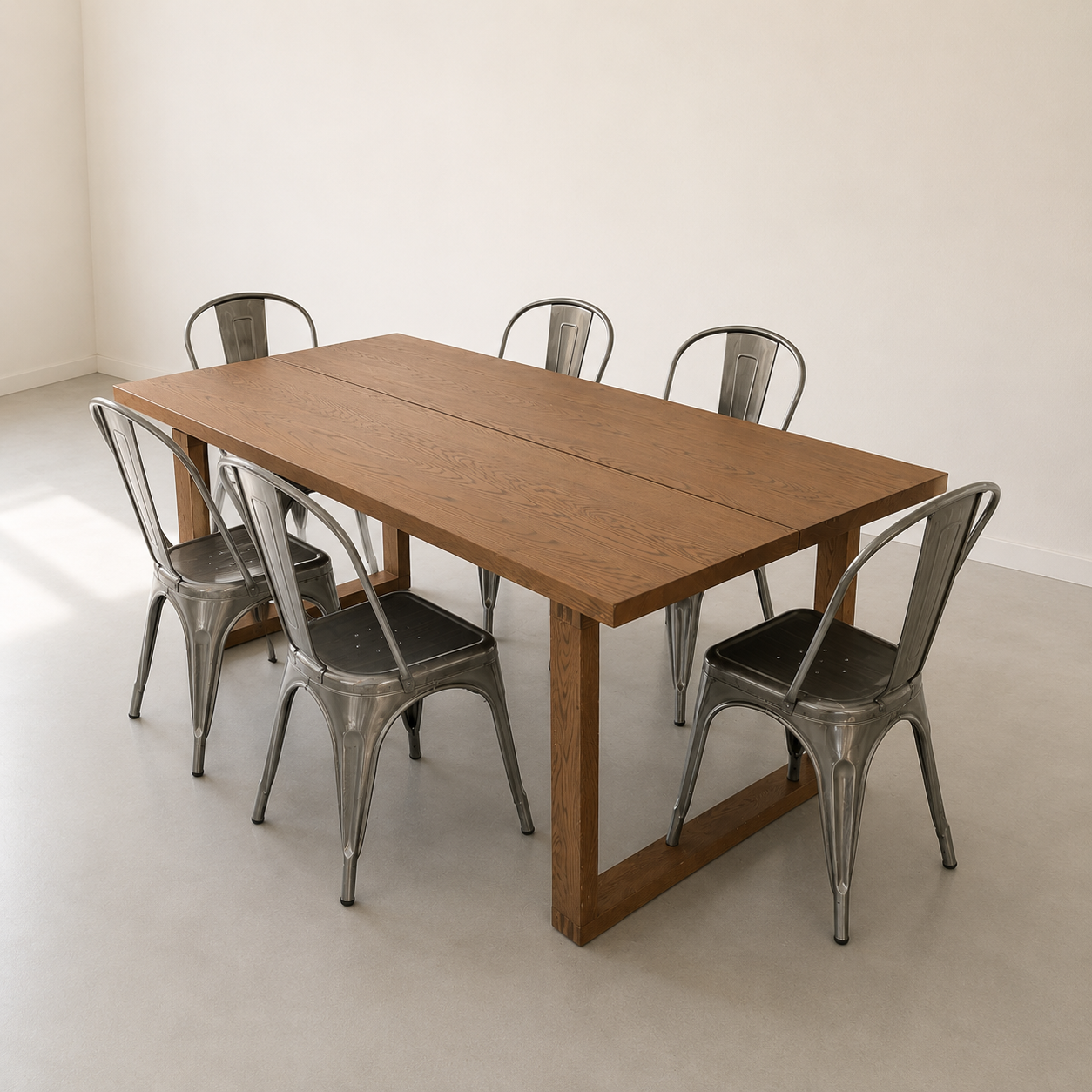 Un tavolo da pranzo rettangolare in legno chiaro con sei sedie in metallo stile industriale, posizionato in una stanza luminosa e minimalista.