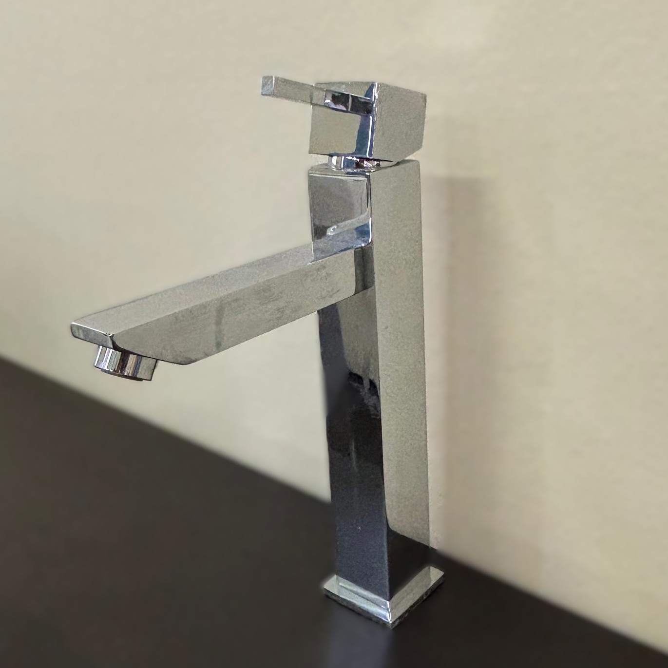 Rubinetto monocomando cromato lucido con design squadrato e moderno, posizionato su una superficie scura.