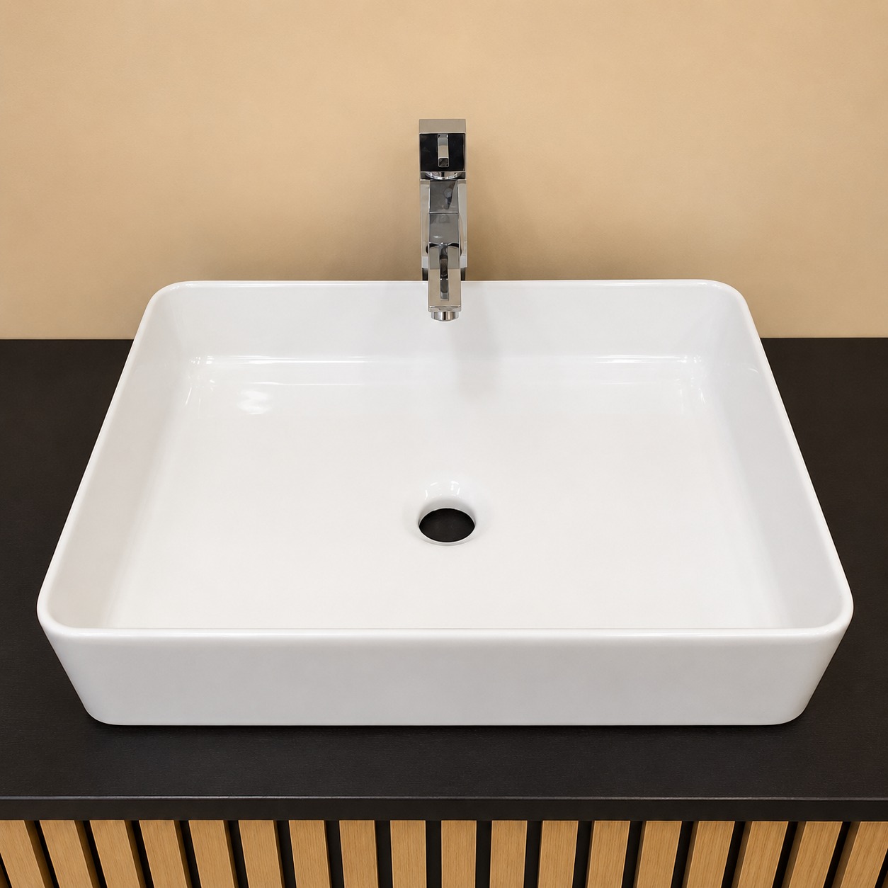 Lavabo rettangolare bianco in ceramica con rubinetto monocomando cromato, installato su un mobile scuro con base a doghe di legno.