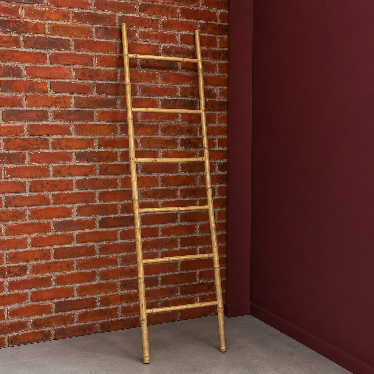 Scala decorativa in bambù naturale appoggiata a una parete di mattoni rossi e una parete bordeaux in un ambiente loft.